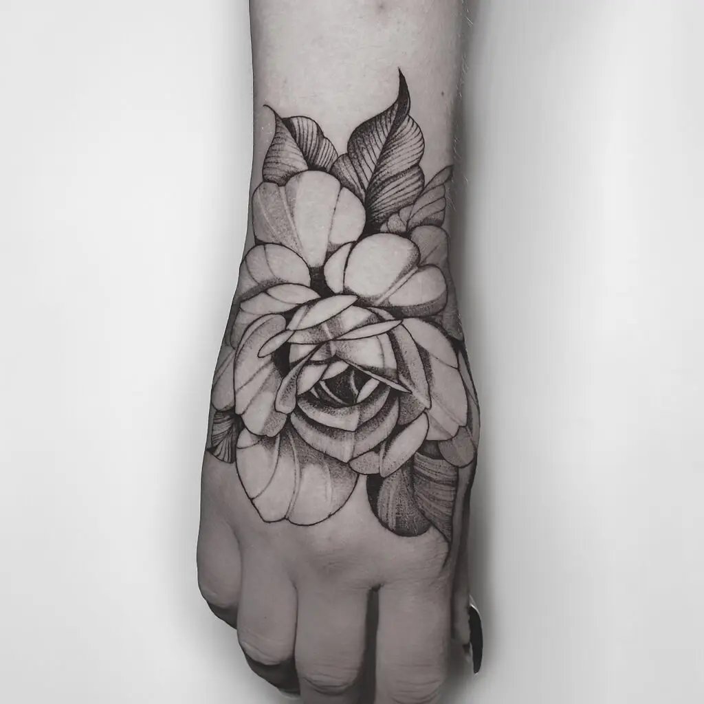 tatuagem fine line de flor delicada na mão